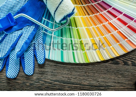 Paint roller protective gloves pantone fan on wooden board.