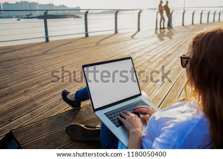 Woman skilled copywriter keyboarding on contemporary laptop computer with empty screen background with copy space for promotional content. Hipster girl typing text on netbook and using applications 