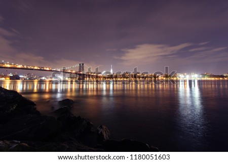 Williamsburg bridge and Manhattan skyline in the evening dusk. Seen from East River Park, Brooklyn, New York.