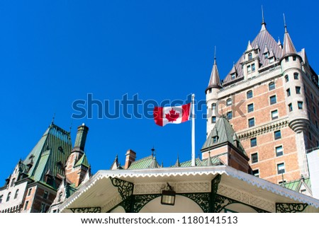 Canadian flag waving in front of the fairmont hotel (Le Chateau Frontenac), Canada's grand railway hotel, at the Dufferin Terrace in Old Quebec, Canada.