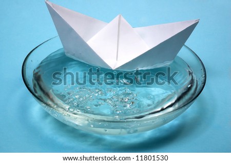 Paper ship in a bowl with water