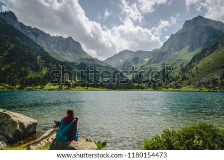 Amazing view at the lake (female hiker at the Lake Laurenti, France Pyrenees Mountains)