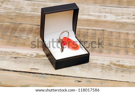 key with blank tag in black gift box on wooden background