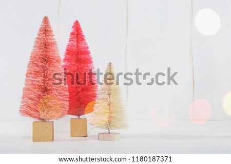 Miniature Christmas trees on a white wooden background