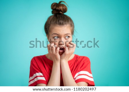 young fit woman fearing greatly dogs, snakes, mice. emotional woman is afraid of thunder, close up portrait, isolated blue background, hipster girl looking aside Royalty-Free Stock Photo #1180202497