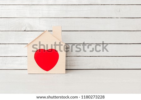 Wood Home Shaped with red heart on white wood over white wood background.