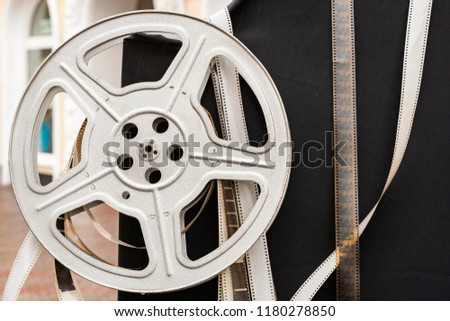 Old Film stock, strip. Old Film reel, bobbin, spool against a dark background. Concept Cinema, filming of movies. Hollywood