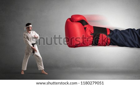Little man fighting with a giant red boxing glove