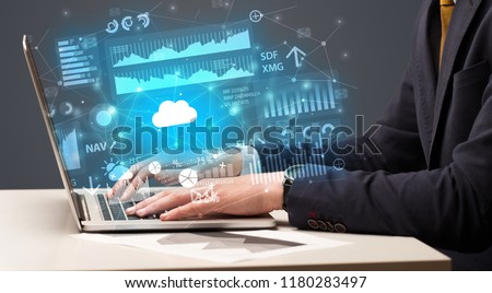 Businessman hand typing on laptop with reports and graphs concept around Royalty-Free Stock Photo #1180283497