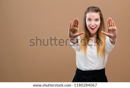 Young woman making a rejection pose on a brown background