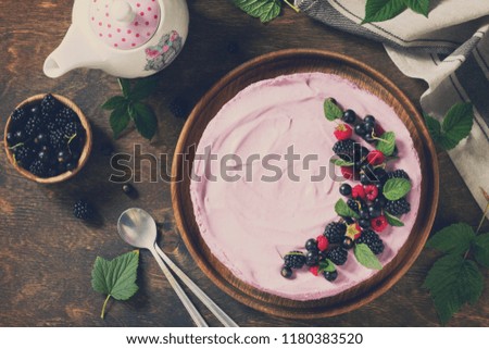 Cake with Black Currant Cream Souffle and Biscuit on a table in a rustic style. Top view flat lay background. Copy space. Toned image.
