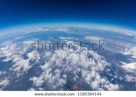 Curvature of planet earth. Aerial shot. Blue sky and clouds over land Royalty-Free Stock Photo #1180384144