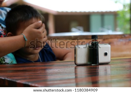 Asian children watching cartoons on the phone screen.
