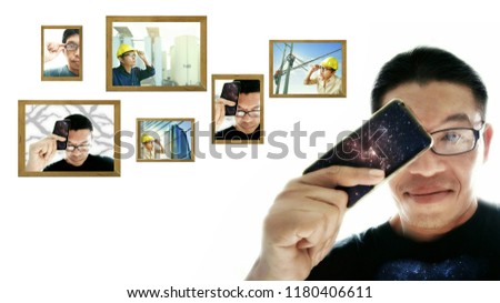 Soft focus portrait of a smiling Asian man in black T-shirt is holding smartphone with many his pictures on white background in enjoy taking photo with mobile phone concept