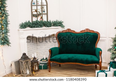 Elegant Interior with green sofa and fireplace decorated for celebrating New Year. Comfort home in Christmas Holidays