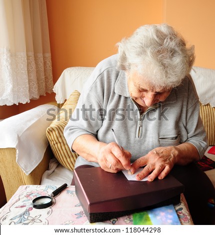 a senior person writing something on table