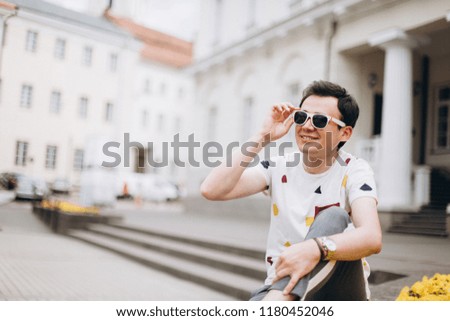 Close up portrait of young cheerful  man on european streets. Positive, freedom concept

