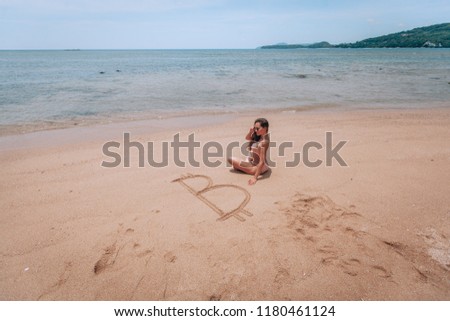 Image of icon bitcoin on golden sand, near sit happy bitcoin girl . Concept freelance, stock exchange
