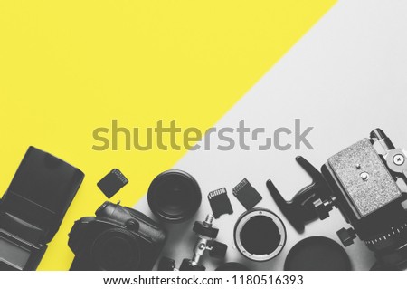 Digital camera, lenses and equipment of the photographer on a grey background