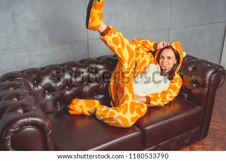 Pajamas in the form of a kangaroo. emotional portrait of a student on the background leather sofa. Crazy and funny man in the suit.  Animator for children's parties