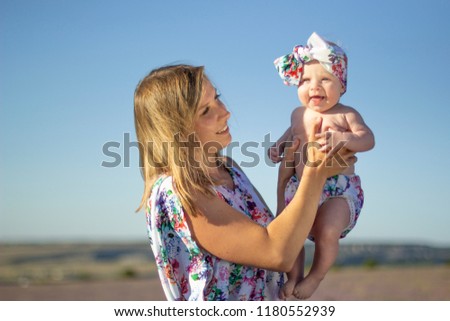 Family photo with a happy child in the hands of mother on lavender field