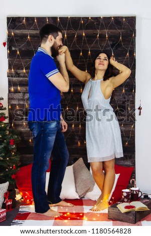 Couple celebrating Christmas, enjoy each other on New Year decoration cozy home party, dance