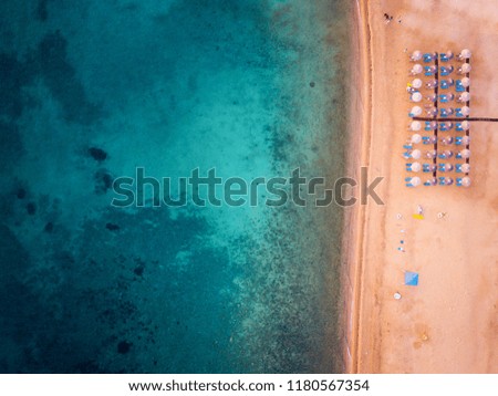 Aerial photo of a beach with beach umbrellas and beach chairs