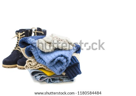 A pile of clothes with boots are on a white background