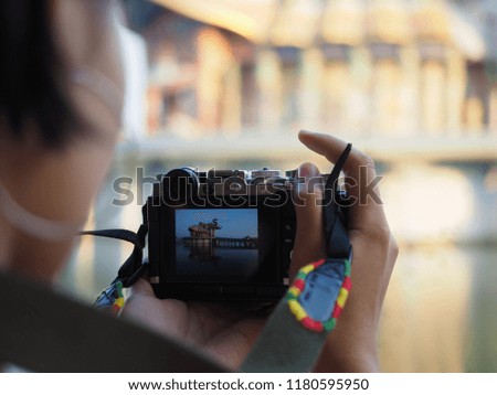 Woman taking a photo in temple at the morning with blurred background, Woman taking photo by camera in temple.