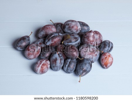 A handful of ripe plums on wooden painted boards. Isolate. Studio photography