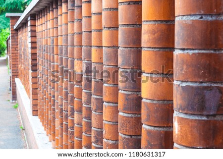 The pillars of the fence made of red brick shaped.