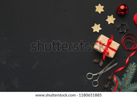 Christmas DIY background with present box, scissors and ribbon on dark table