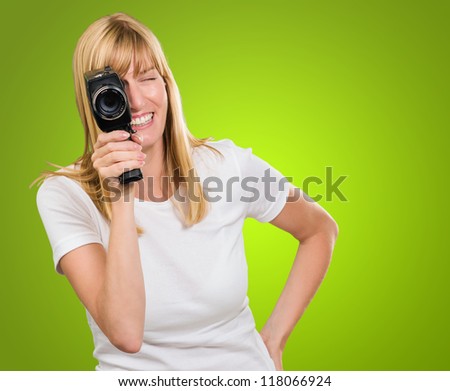 Happy Woman Looking Through Camera against a green background