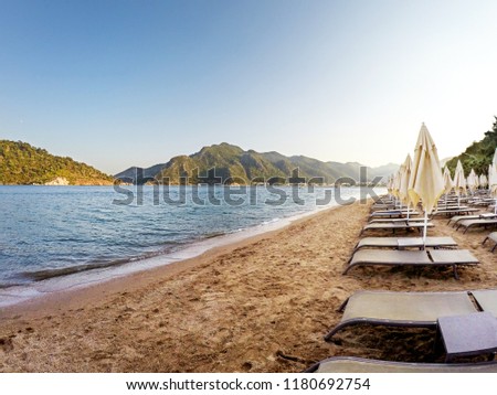 Beautiful mountains and sea beach with sun beds and umbrellas in Marmaris, Turkey
