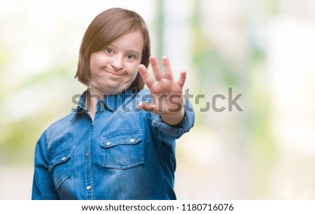 Young adult woman with down syndrome over isolated background doing stop sing with palm of the hand. Warning expression with negative and serious gesture on the face.