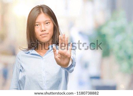 Young asian business woman over isolated background doing stop sing with palm of the hand. Warning expression with negative and serious gesture on the face.