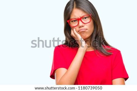 Young asian woman wearing glasses over isolated background thinking looking tired and bored with depression problems with crossed arms.