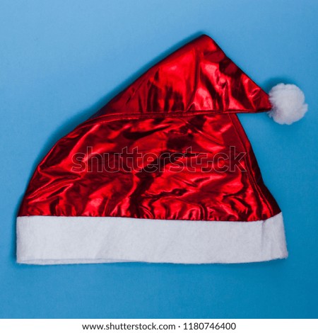 Red cap of Santa Claus on a blue background - New Year's attributes