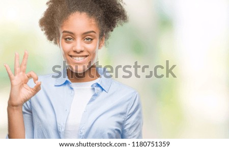 Young afro american woman over isolated background smiling positive doing ok sign with hand and fingers. Successful expression.
