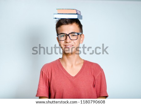 young man holds book on his head, isolated studio photo on background