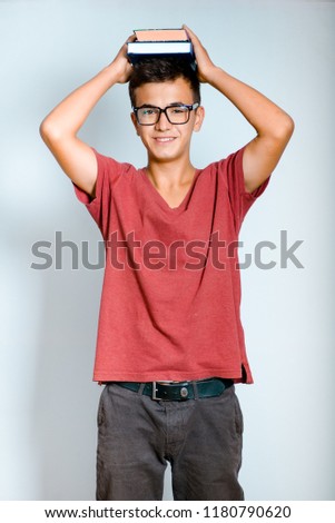young man holds book on his head, isolated studio photo on background