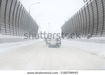 Car with lights on a snow covered road.