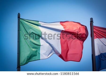 Italian flag fluttering in the wind, with blue sky. Green, White, Red and Azure are Italian national colors.