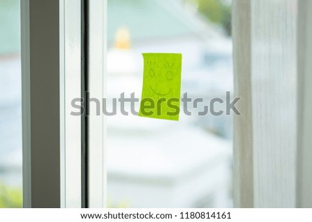 Abstract Happy smile drawing in paper stick on window glass. 