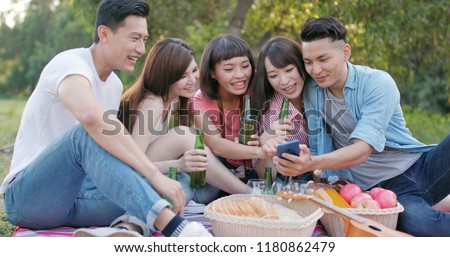 Asian Young friends taking selfie on cellphone in the park