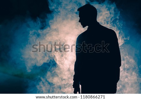 The man silhouette standing in the smoke. evening night time Royalty-Free Stock Photo #1180866271
