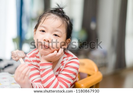 Portrait of a cute asian girl with ice cream at home.
