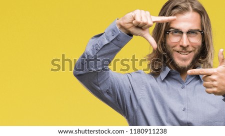 Young handsome business man with long hair over isolated background smiling making frame with hands and fingers with happy face. Creativity and photography concept.