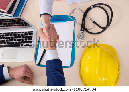 Doctor and manager agreeing industrial insurance coverage Royalty-Free Stock Photo #1180914934