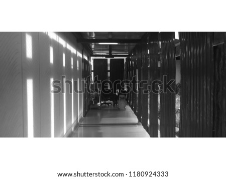Sunshine through the channel of the zinc wall. Black and white picture with white border.